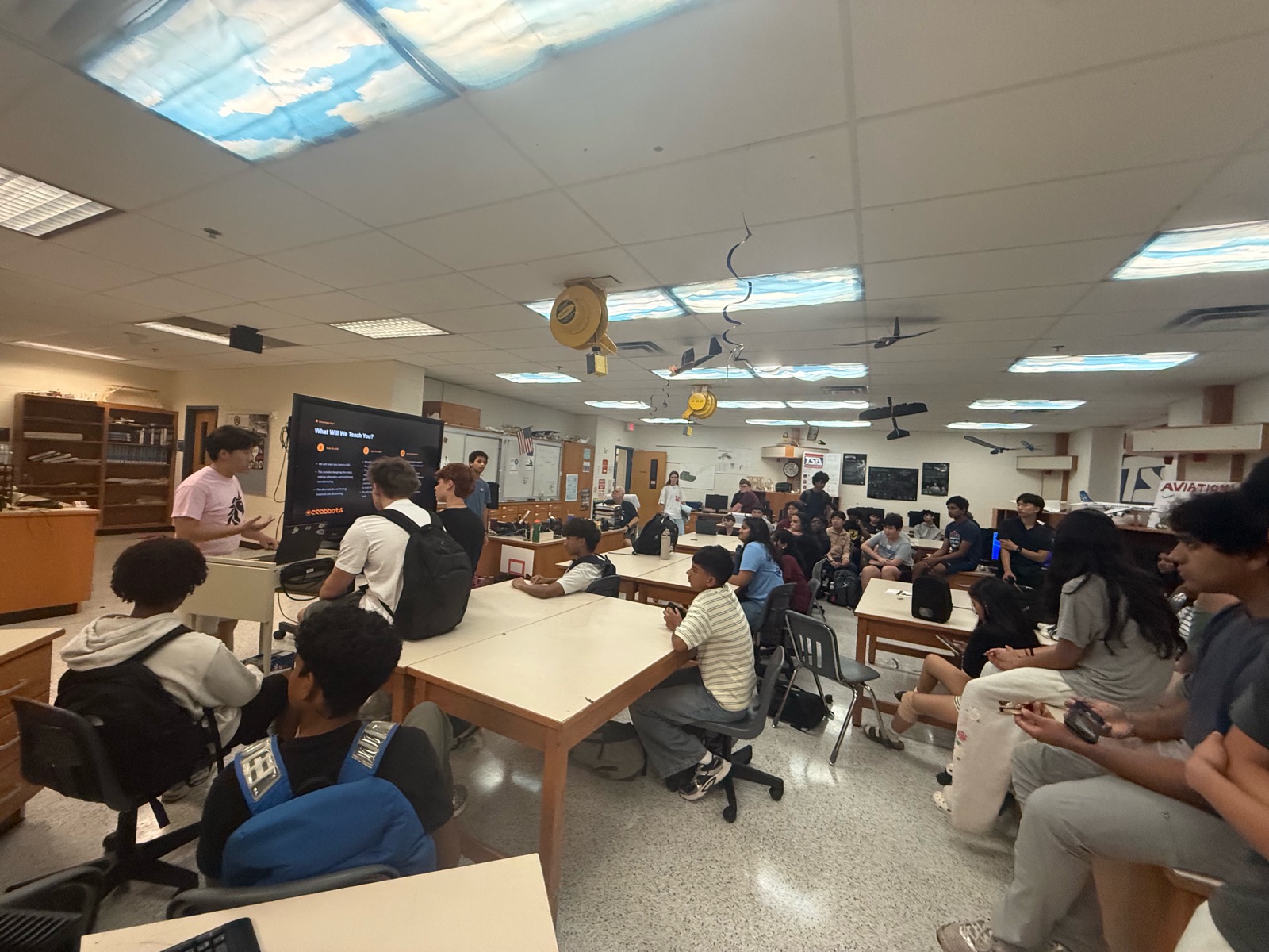 A student presents a &ldquo;What Will We Teach You?&rdquo; slide to a room of students